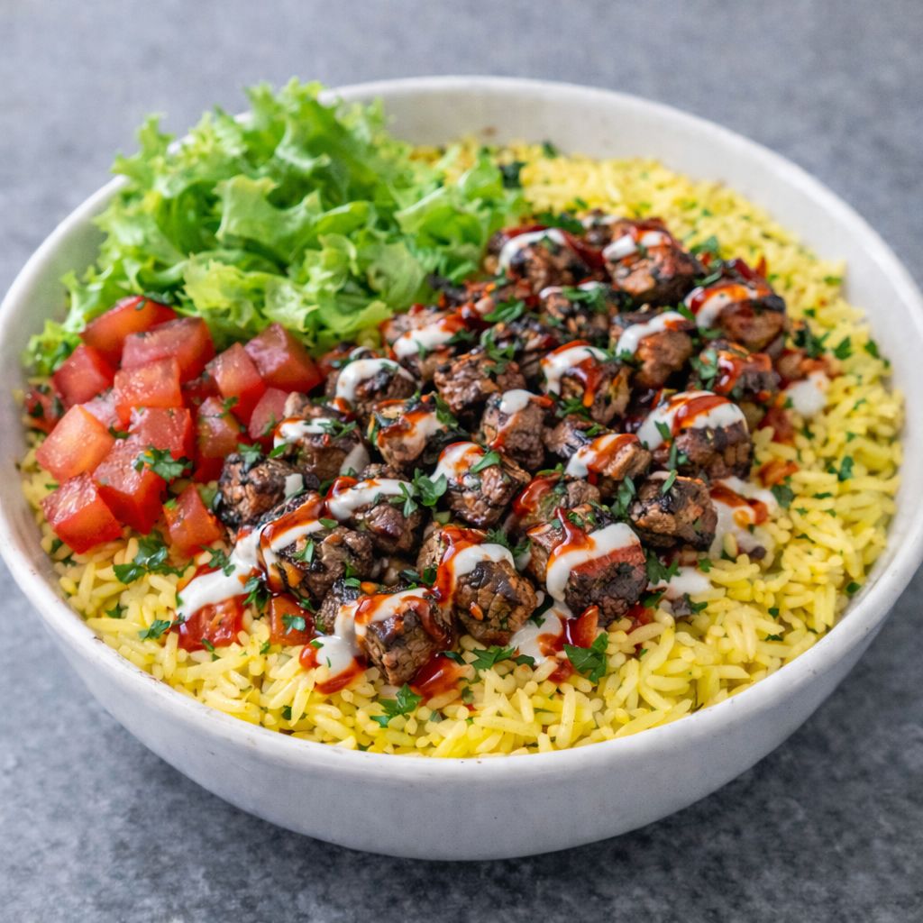 Steak Bowl Juicy steak served over rice with fresh lettuce and tomatoes, topped with a drizzle of our creamy white sauce. Choose between regular or spicy rice.